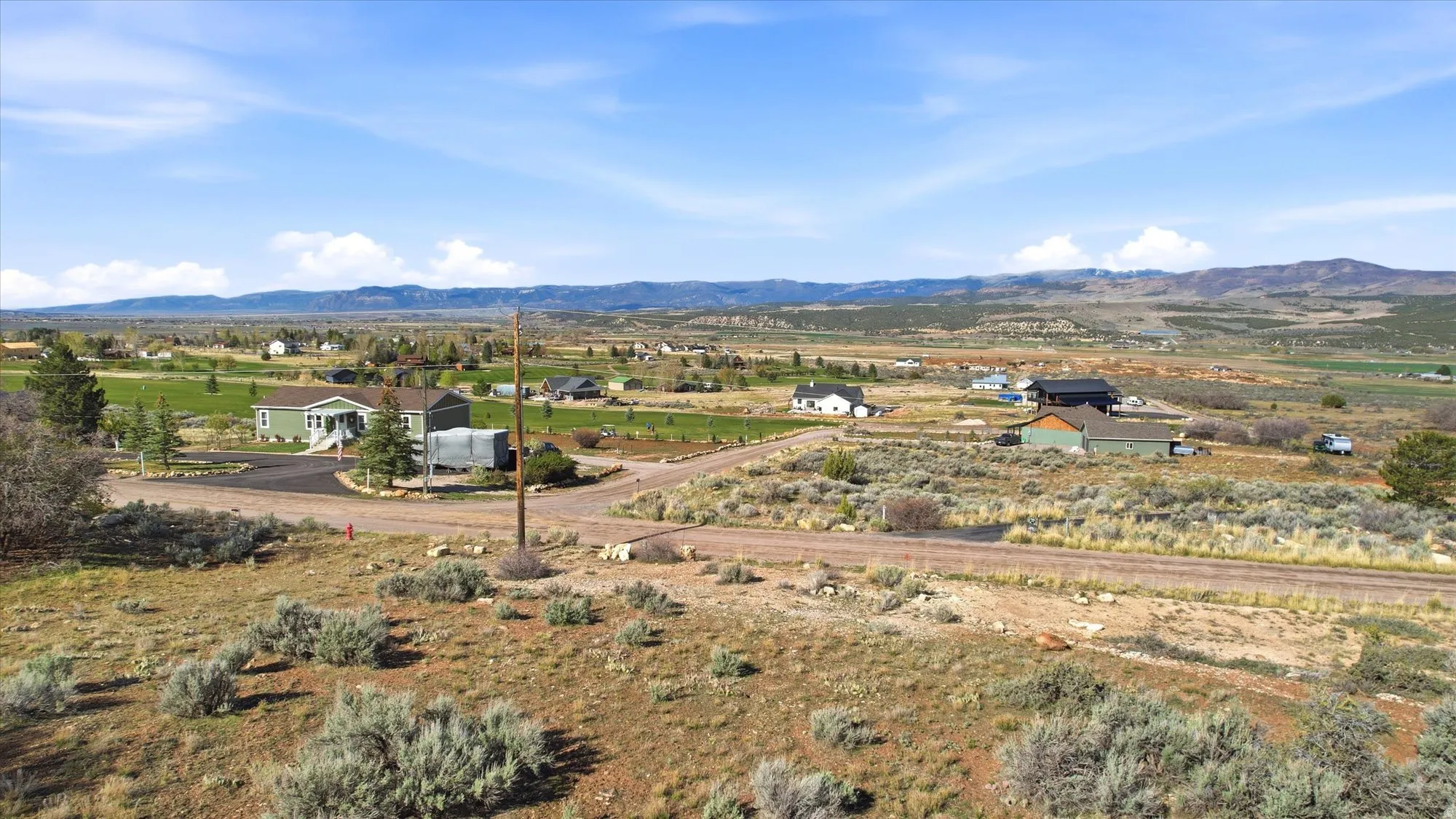 Expansive rural landscape featuring distant mountains and a clear sky