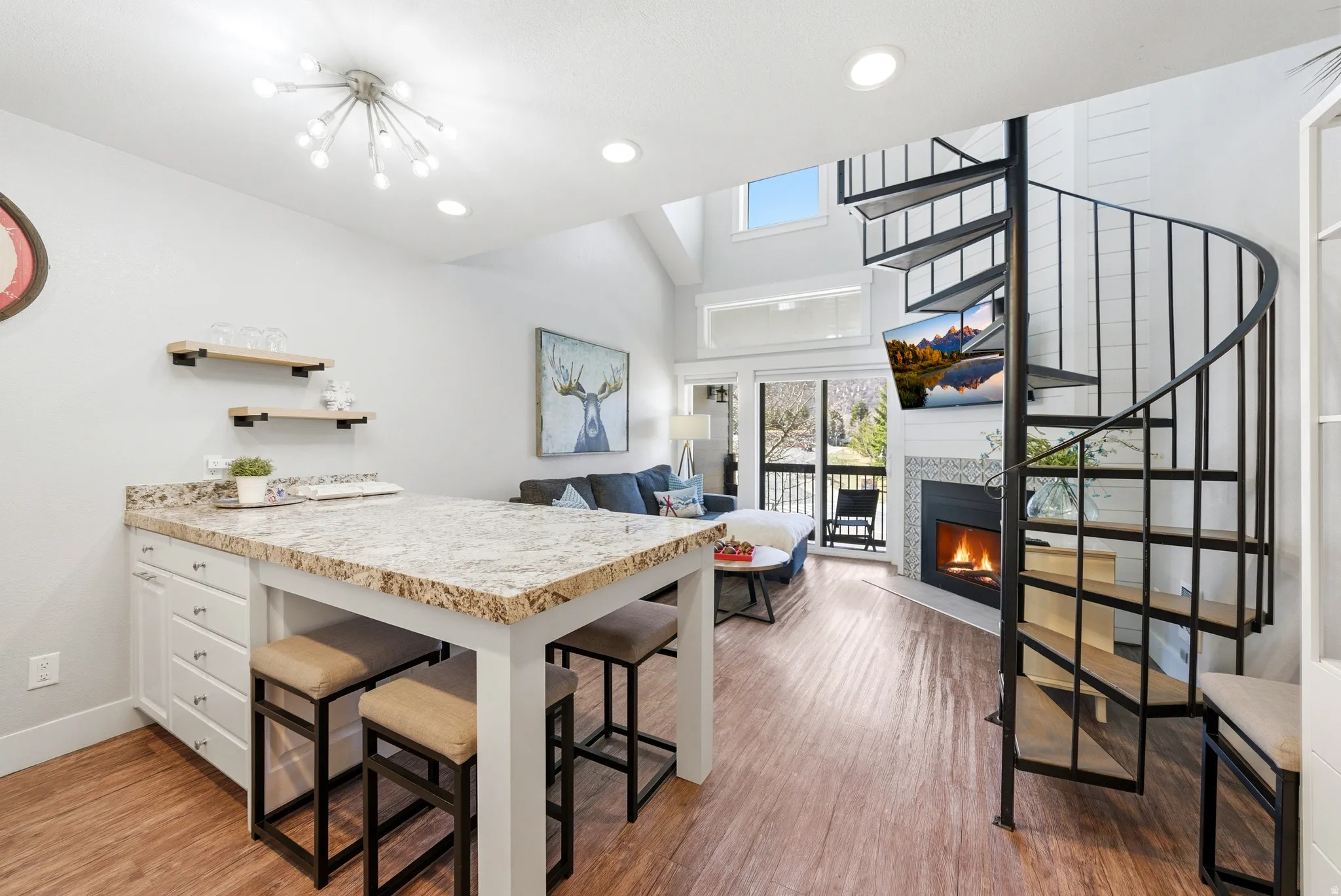 Kitchen with a peninsula, light countertops, a breakfast bar, open shelves, and white cabinetry
