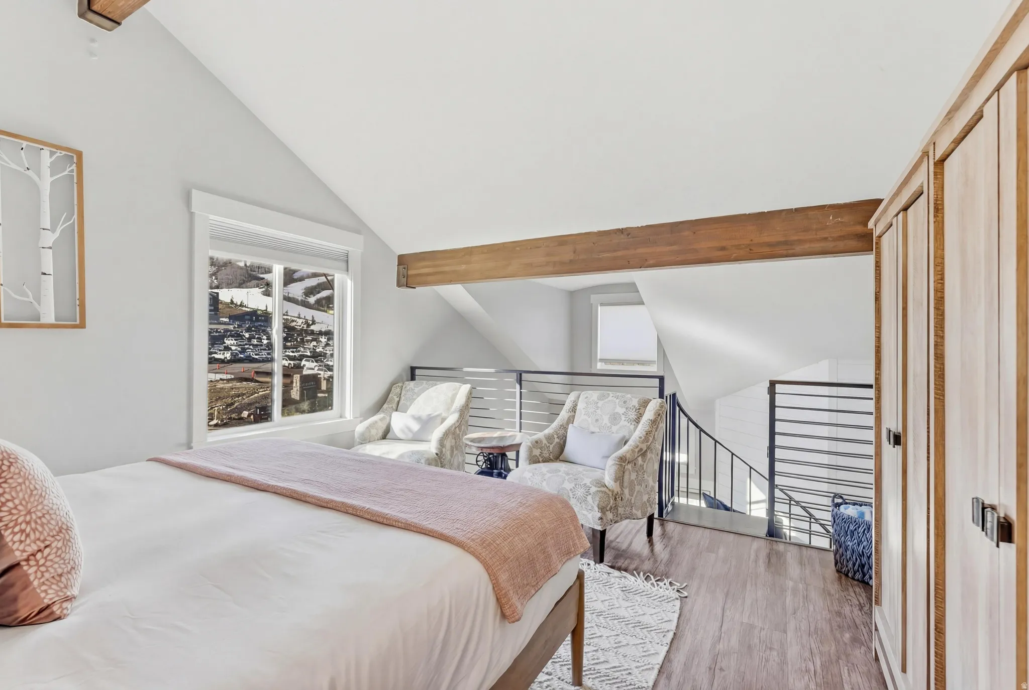 Bedroom with wood finished floors and vaulted ceiling with beams