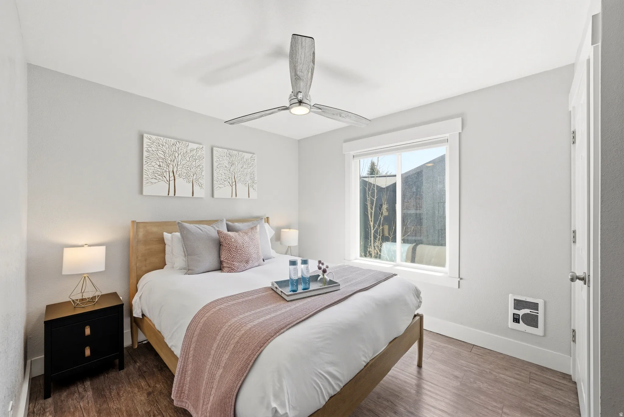 Bedroom featuring wood finished floors, ceiling fan, and heating unit