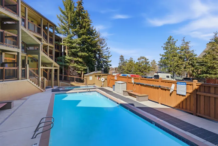 Community pool featuring a fenced backyard, a patio, and a community hot tub
