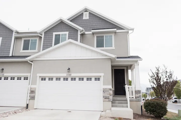 Craftsman house featuring board and batten siding, concrete driveway, stone siding, and stucco siding