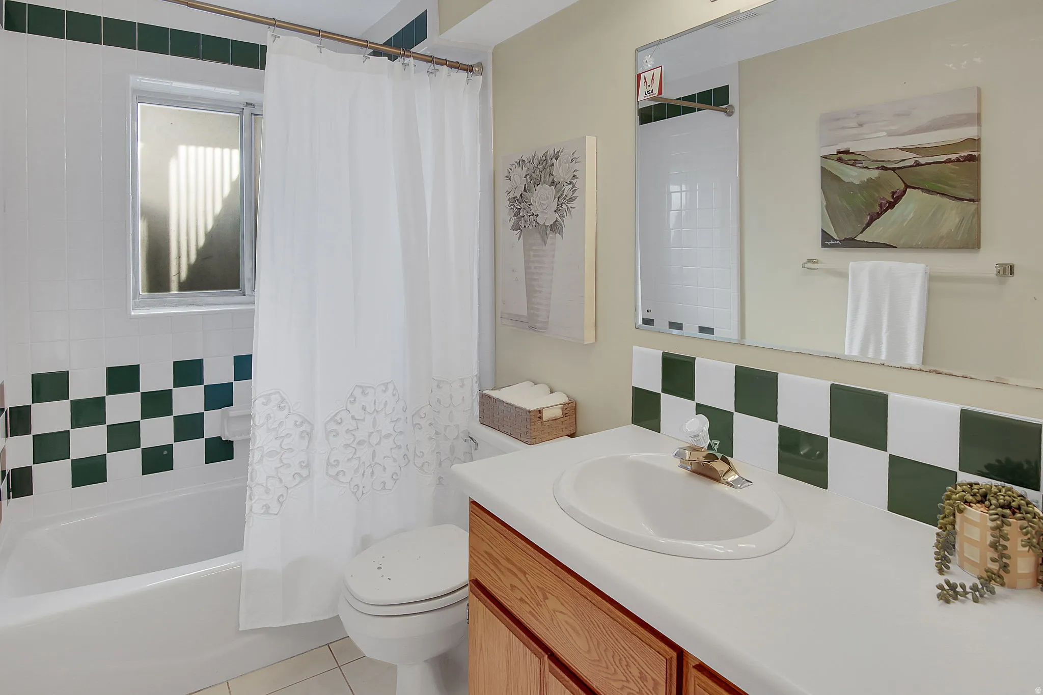 Bathroom featuring vanity, shower / bath combo, backsplash, and light tile patterned flooring