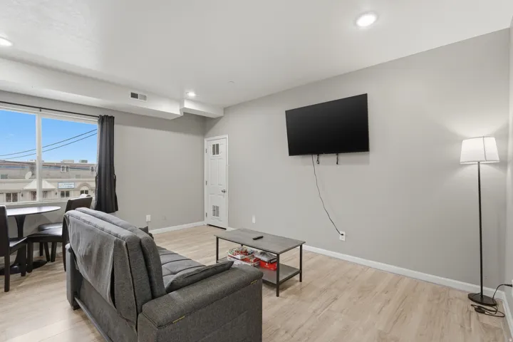 Living room with light wood finished floors and recessed lighting