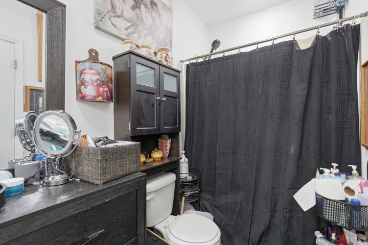 Full bath featuring curtained shower and vanity