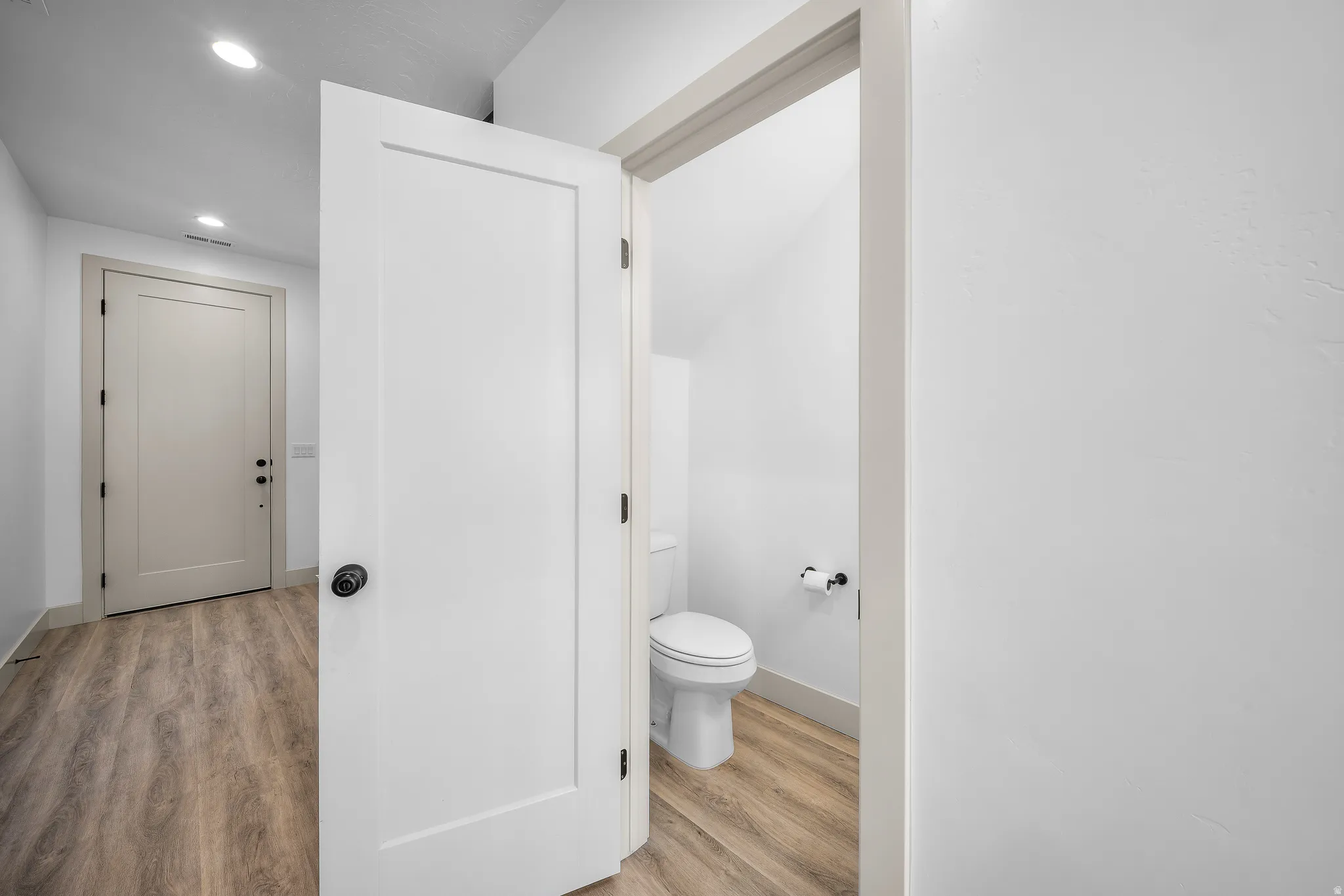 Bathroom with light wood finished floors and recessed lighting