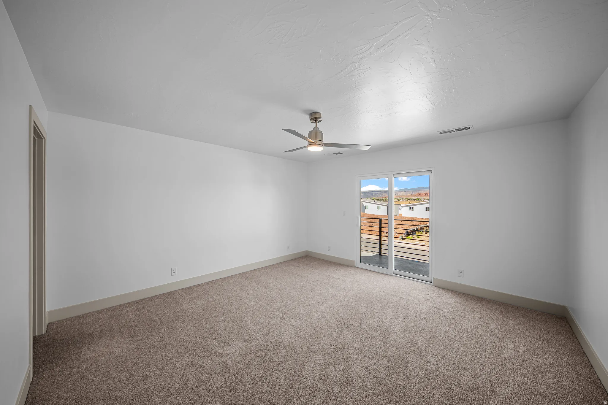 Spare room with light colored carpet and ceiling fan