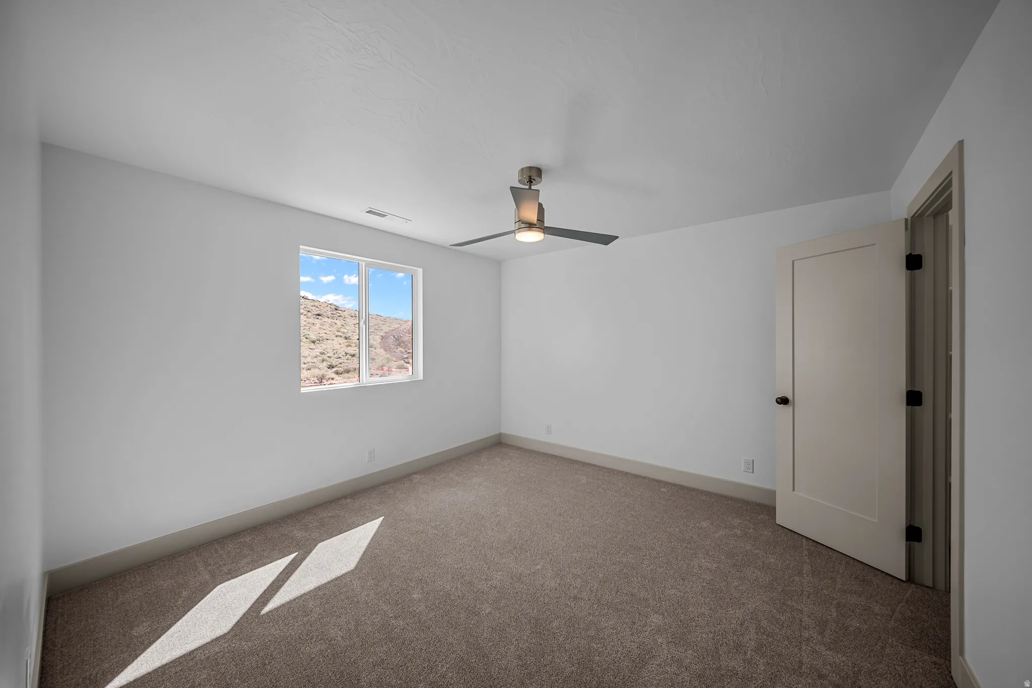 Unfurnished room with carpet and a ceiling fan