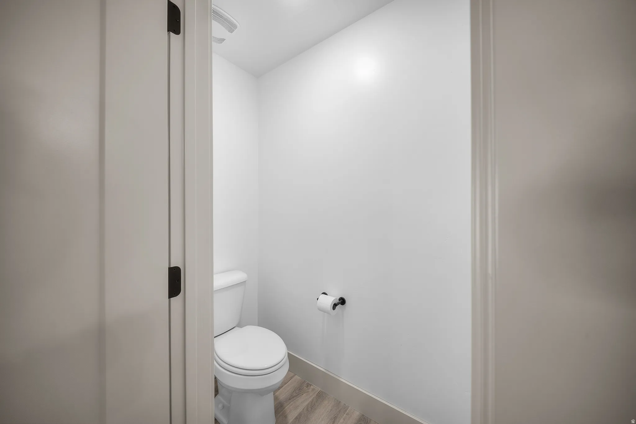 Bathroom with light wood-style flooring and toilet