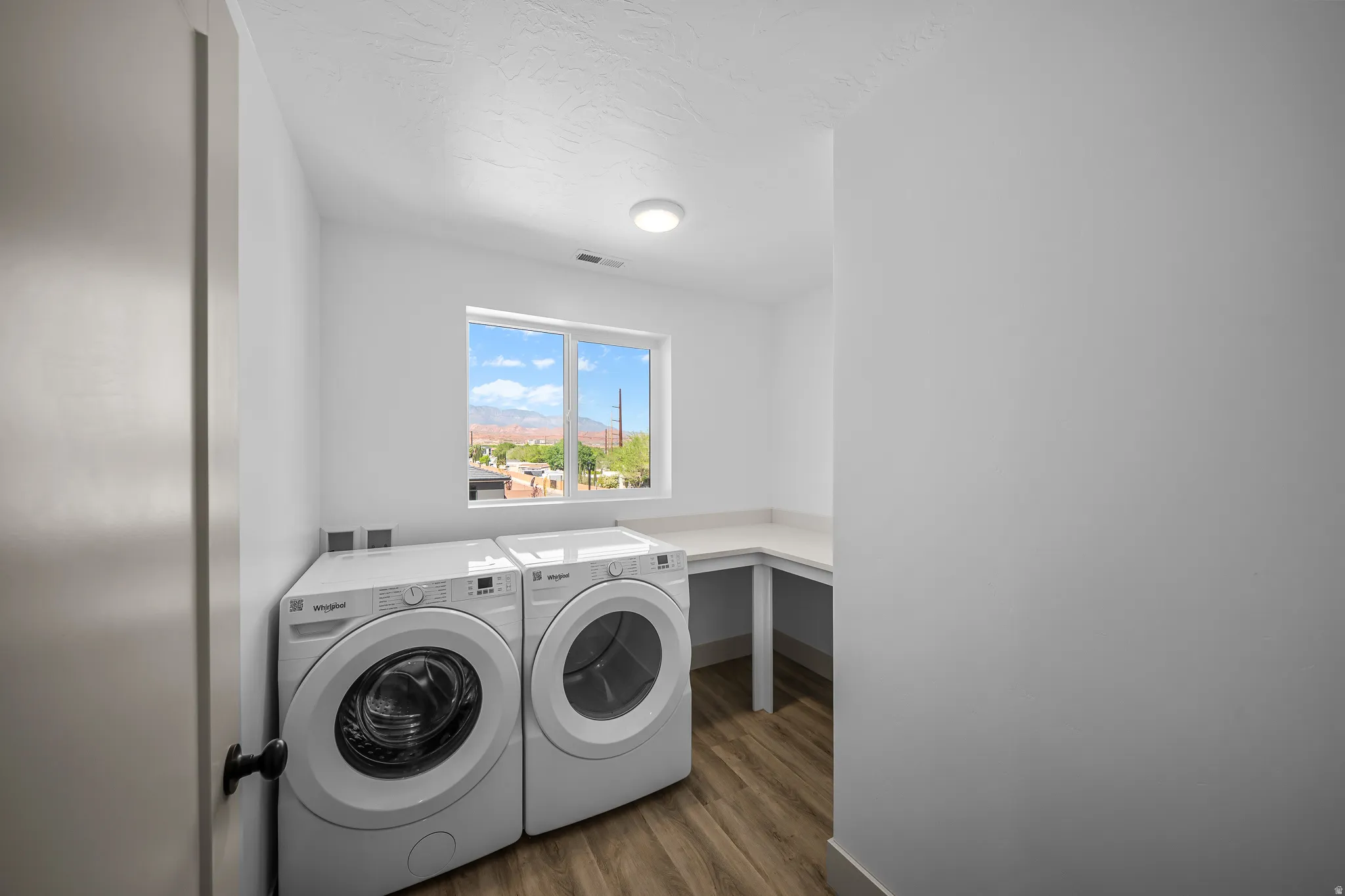 Laundry area featuring dark wood finished floors and independent washer and dryer