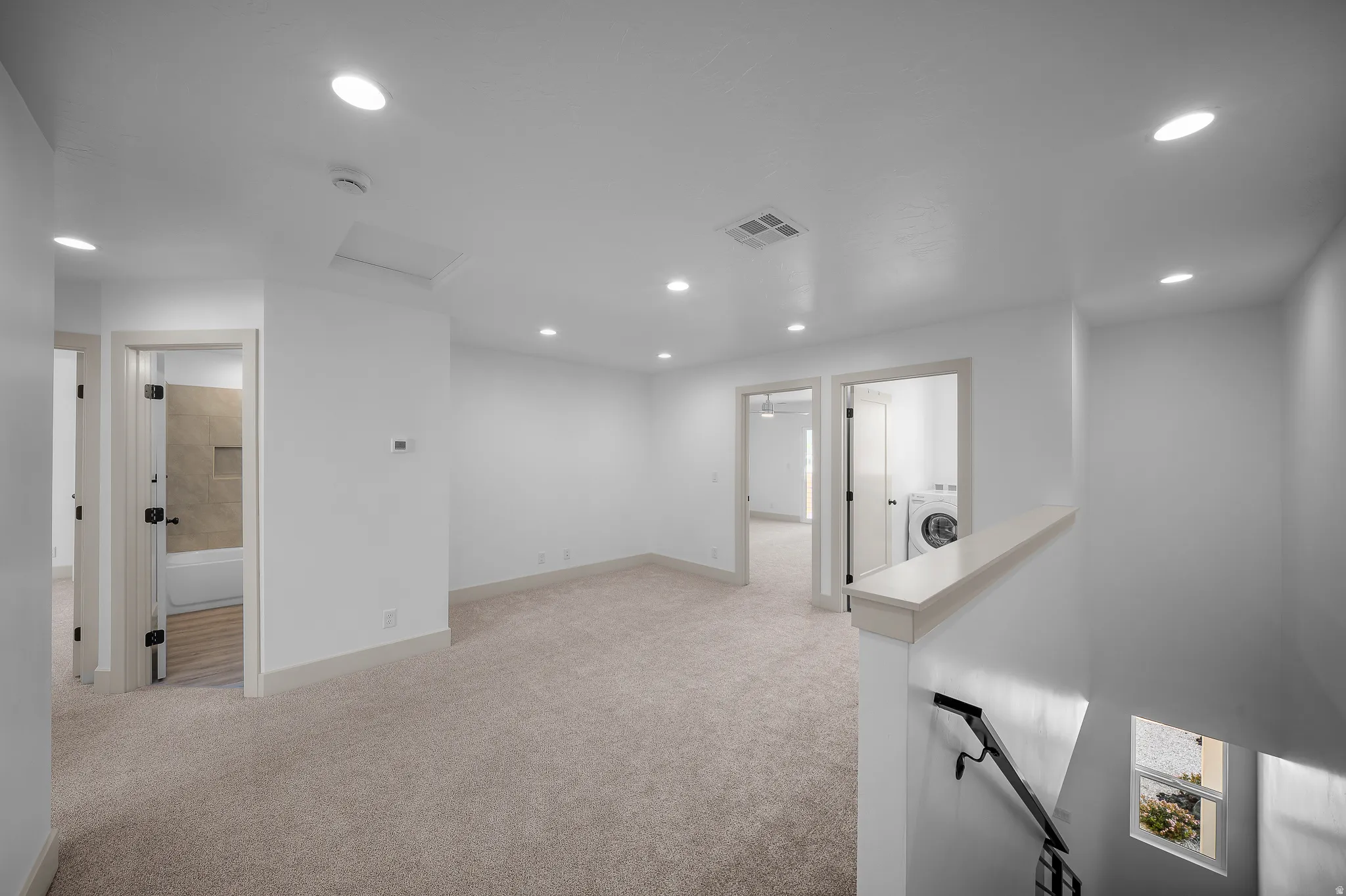 Hallway featuring an upstairs landing, light carpet, recessed lighting, and washer / clothes dryer