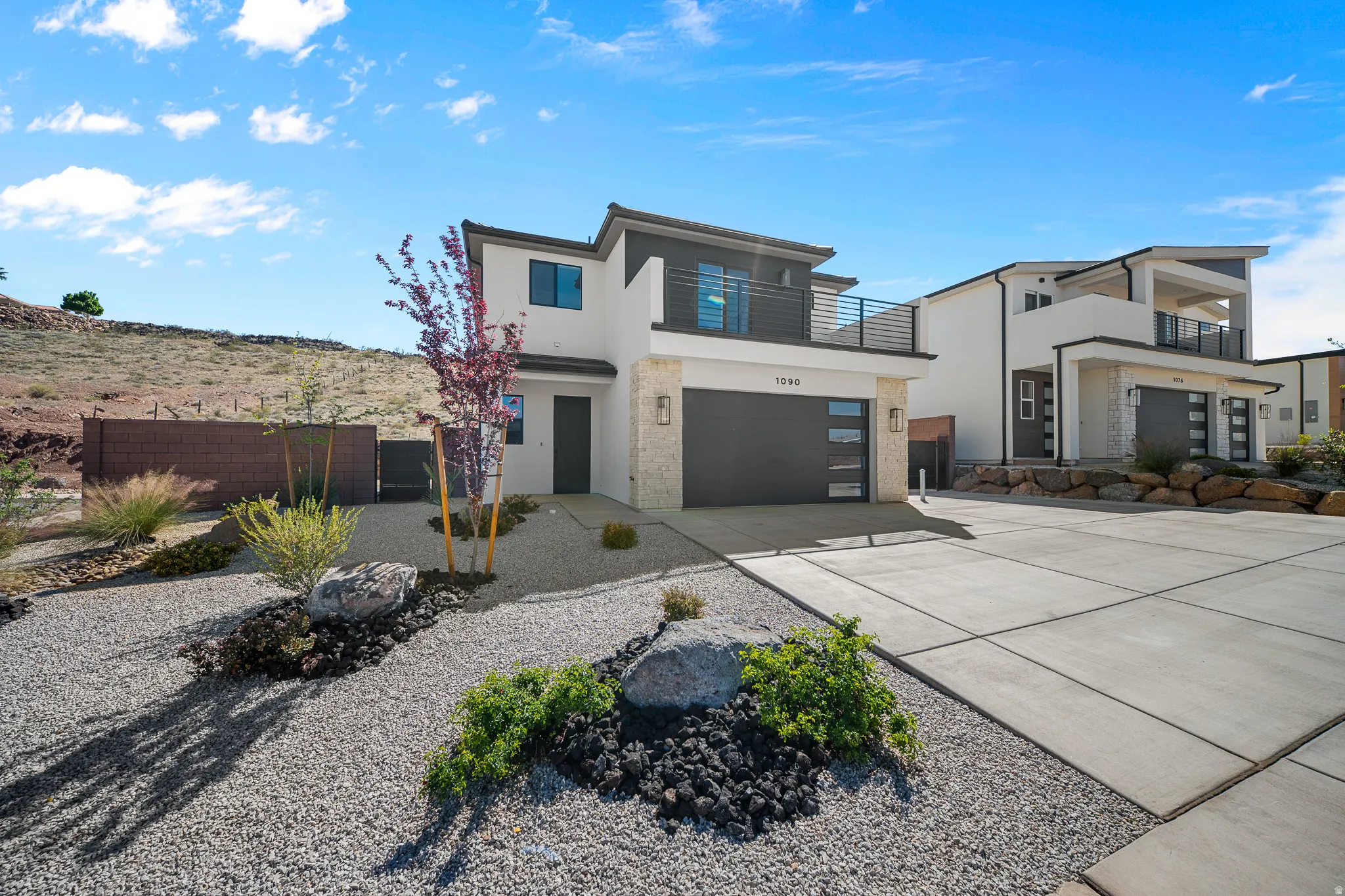 Modern home with driveway, a balcony, stucco siding, and a garage