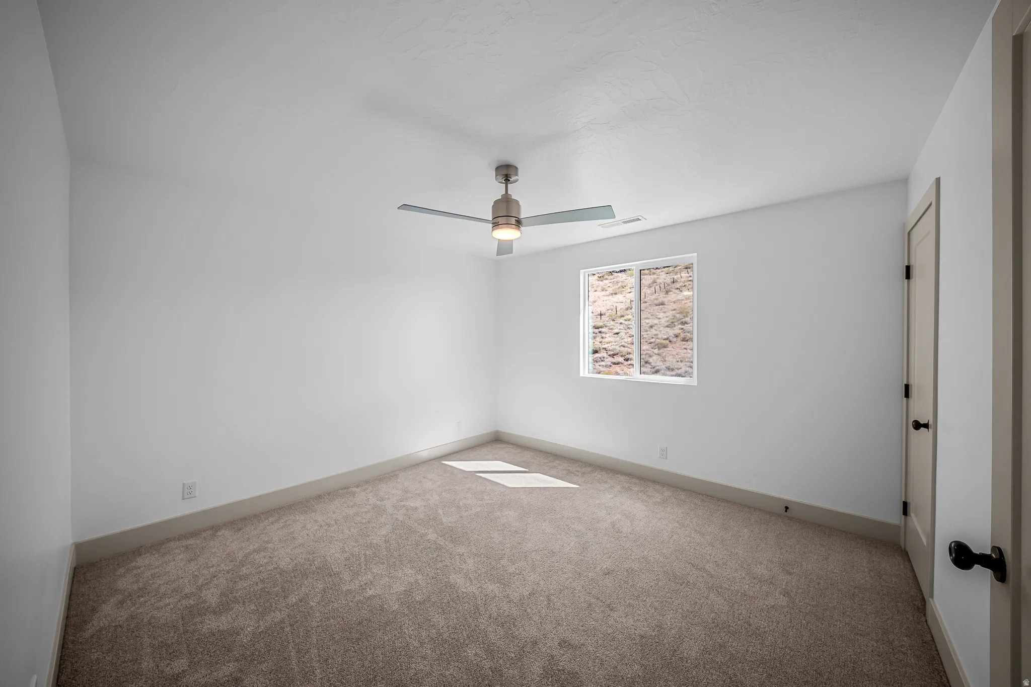 Unfurnished room featuring carpet flooring and a ceiling fan