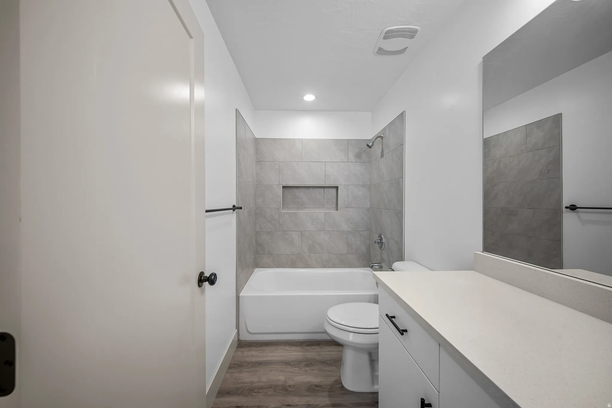 Full bath featuring bathtub / shower combination, vanity, and dark wood-style flooring
