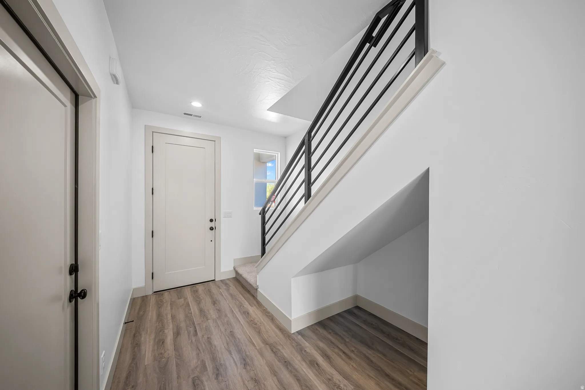 Entryway featuring light wood finished floors and recessed lighting