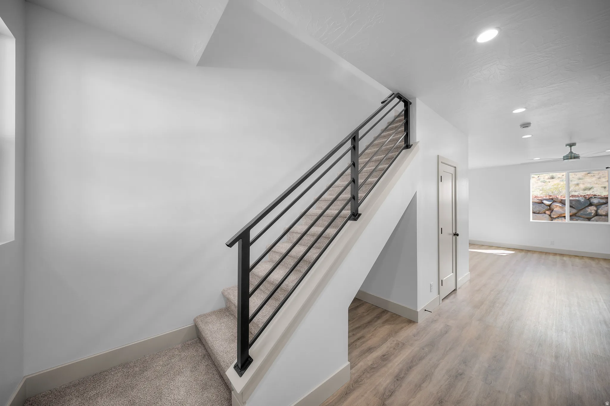 Stairway with wood finished floors and recessed lighting