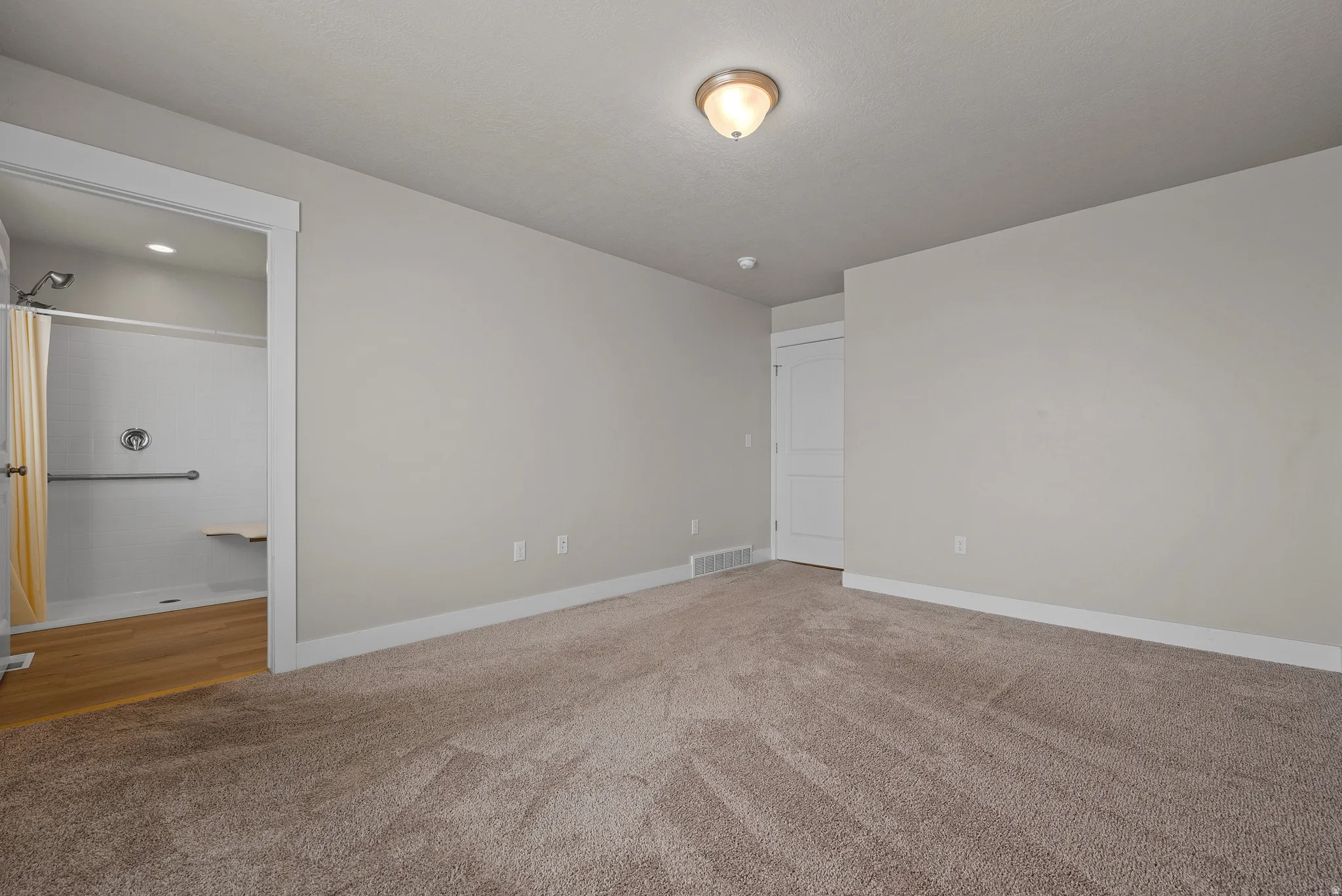 Spare room featuring light carpet and baseboards