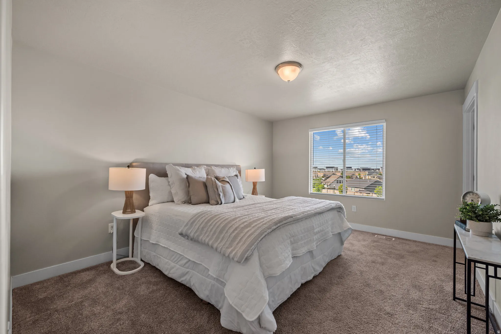 Carpeted room featuring a large window, neutral wall paint, and a semi-flush mount ceiling light