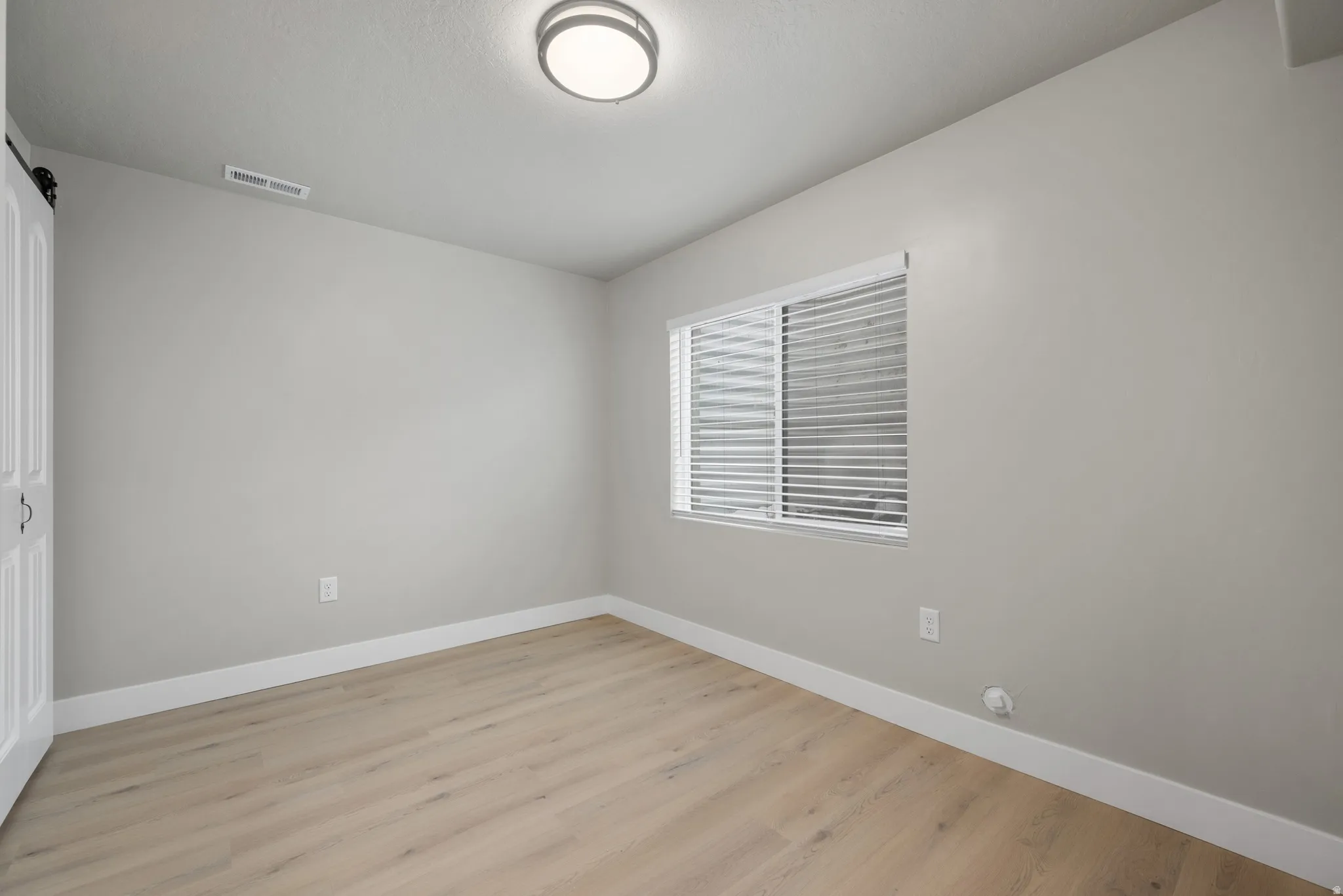 Unfurnished bedroom with a closet and light wood-type flooring