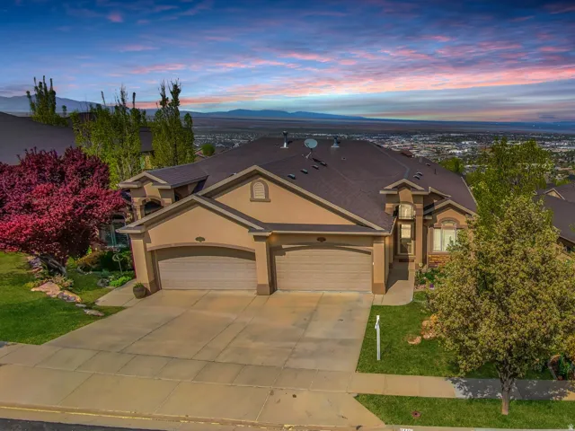 View of front of house featuring stucco siding, a garage, driveway, and a front yard