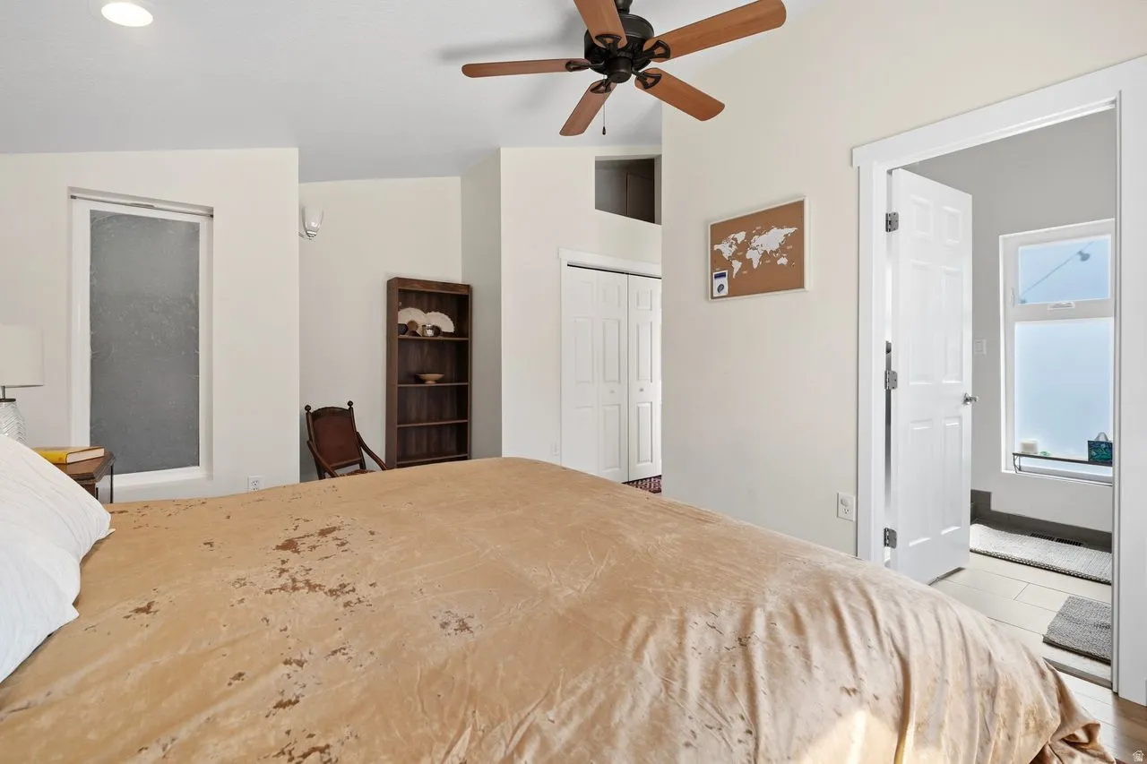 primary Bedroom with vaulted ceiling, a closet, ceiling fan, and light tile patterned floors