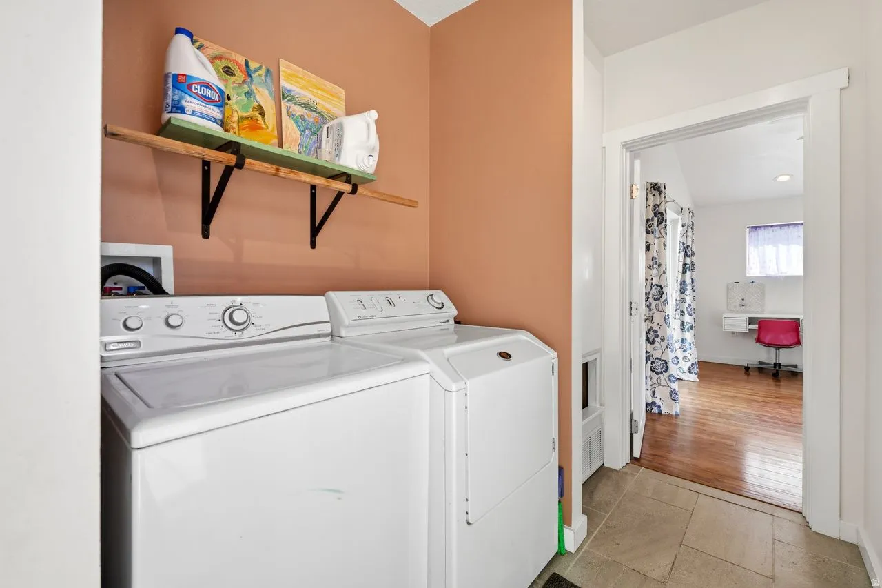 Laundry area with light tiled, separate washer and dryer