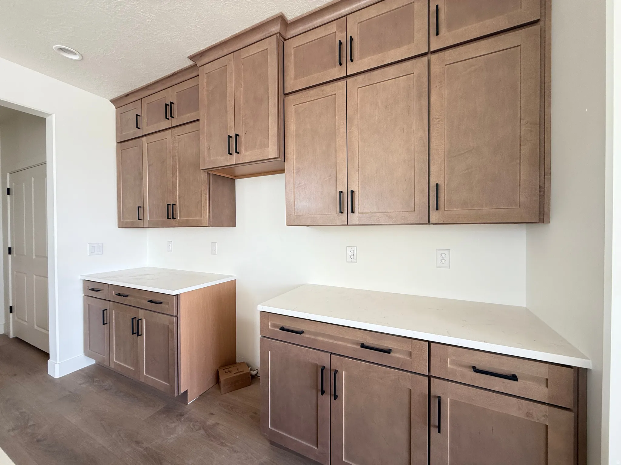 Kitchen featuring wood finish cabinets, dark wood-style flooring, and light stone counters