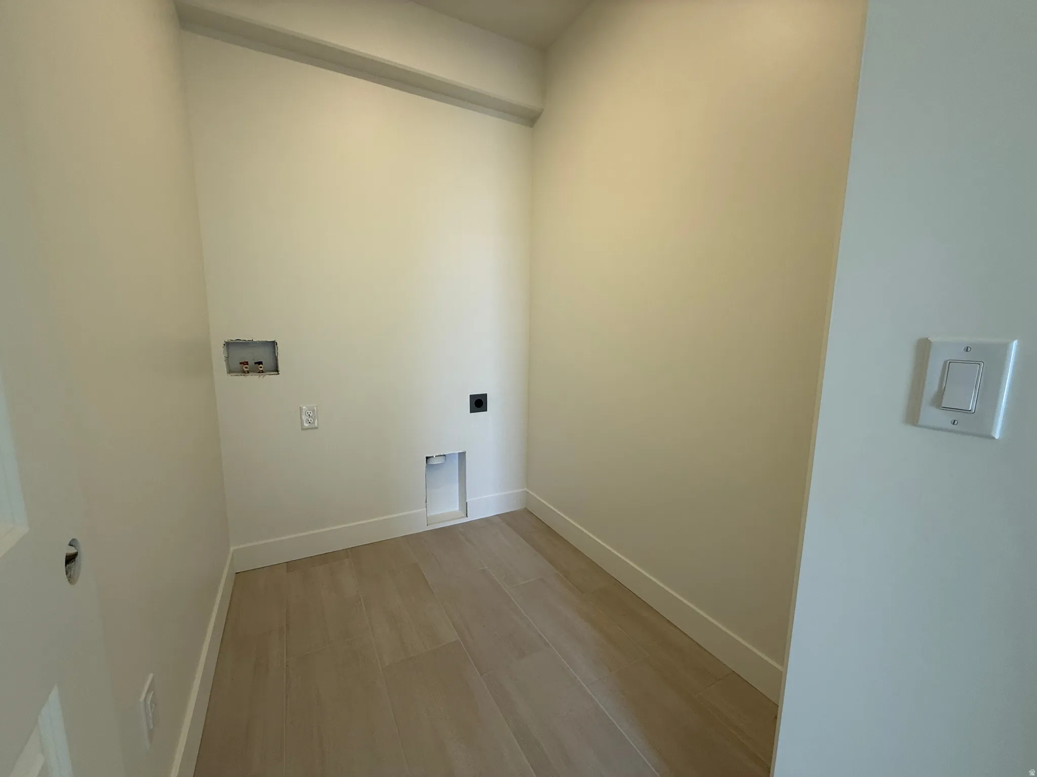 Laundry room featuring light wood finished floors, washer hookup, and electric dryer hookup