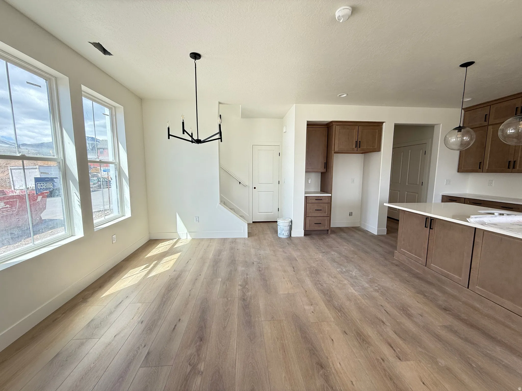 Unfurnished dining area featuring hanging lights and light wood-style floors