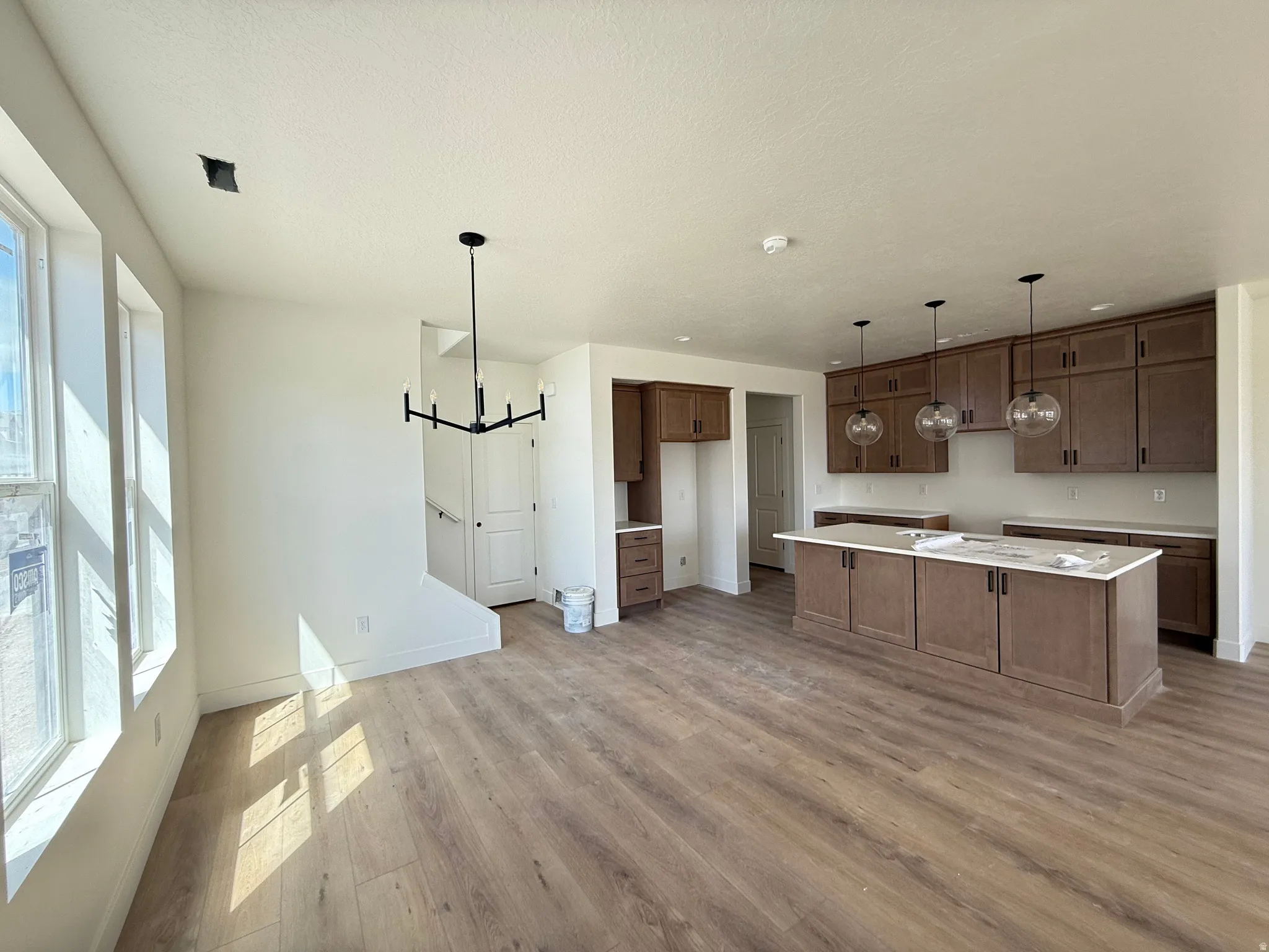 Kitchen featuring suspended lighting, light wood-style flooring, and a kitchen island
