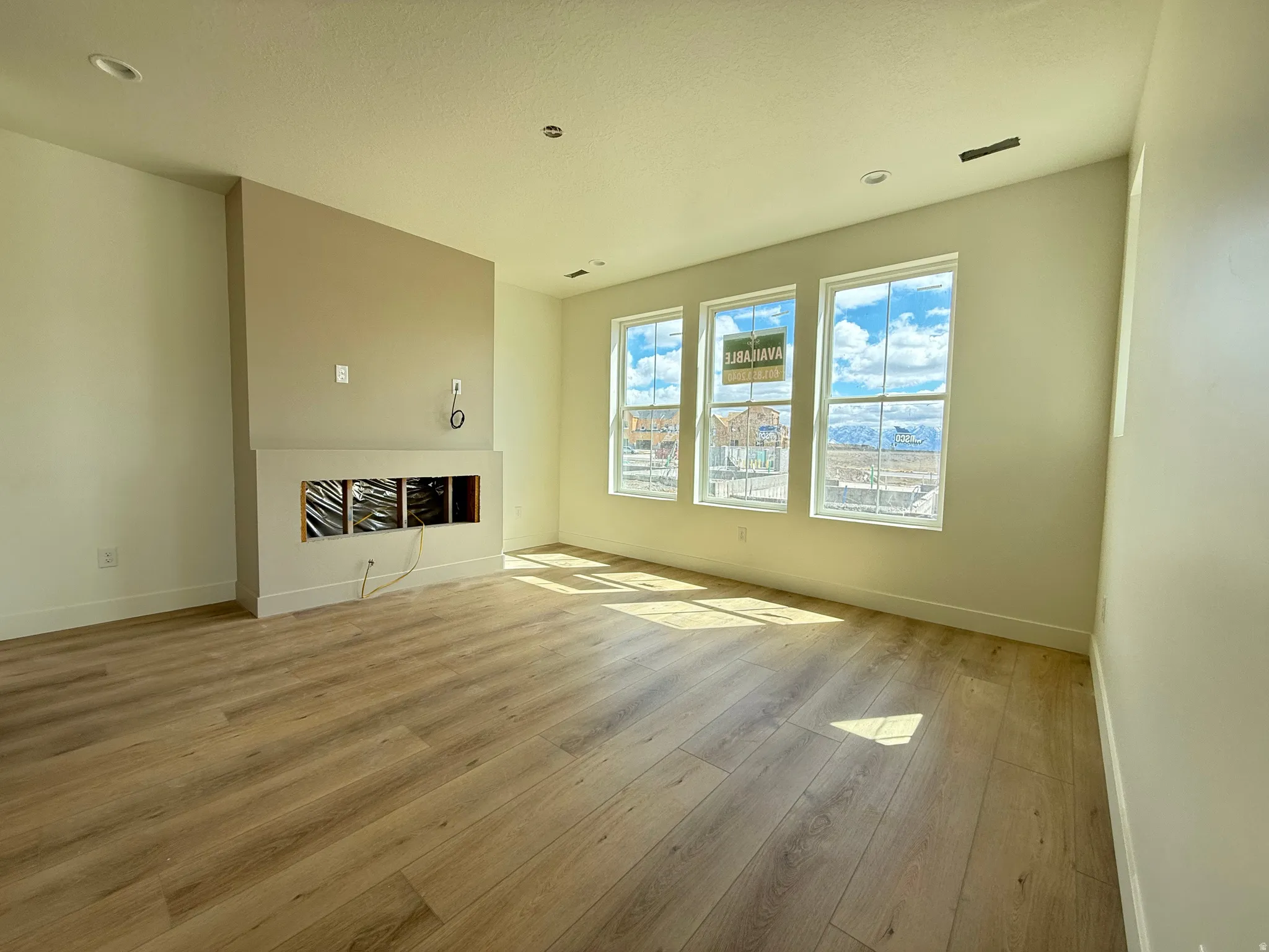 Unfurnished living room with light wood-type flooring and a fireplace