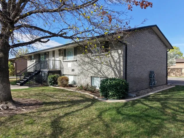 View of side of property with brick siding and a lawn