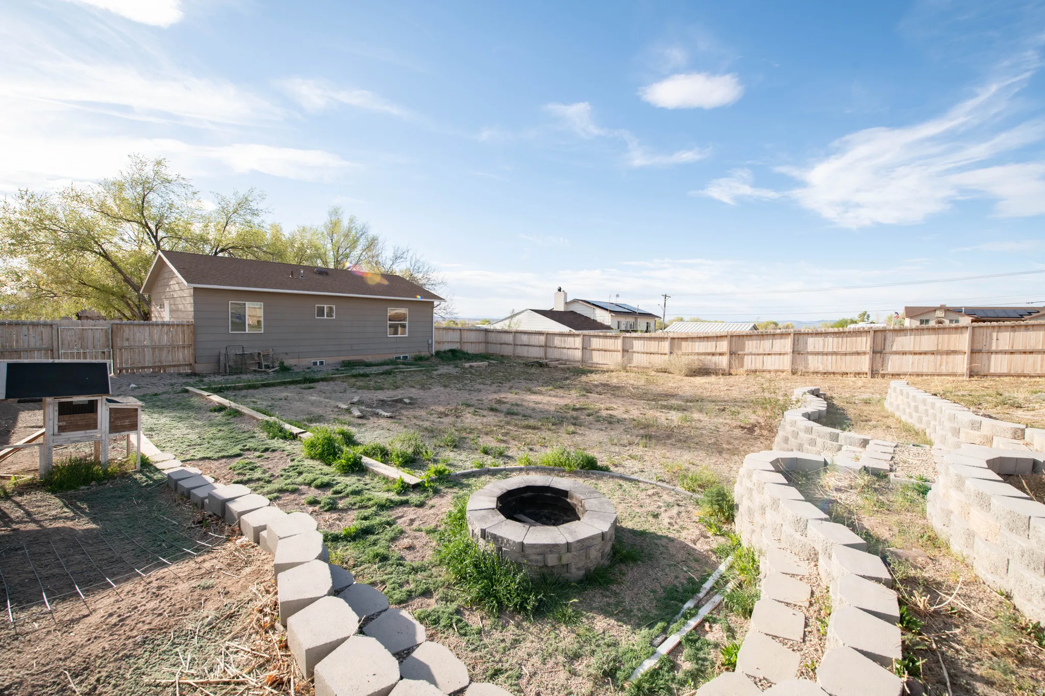 Fenced backyard featuring a fire pit and a patio area