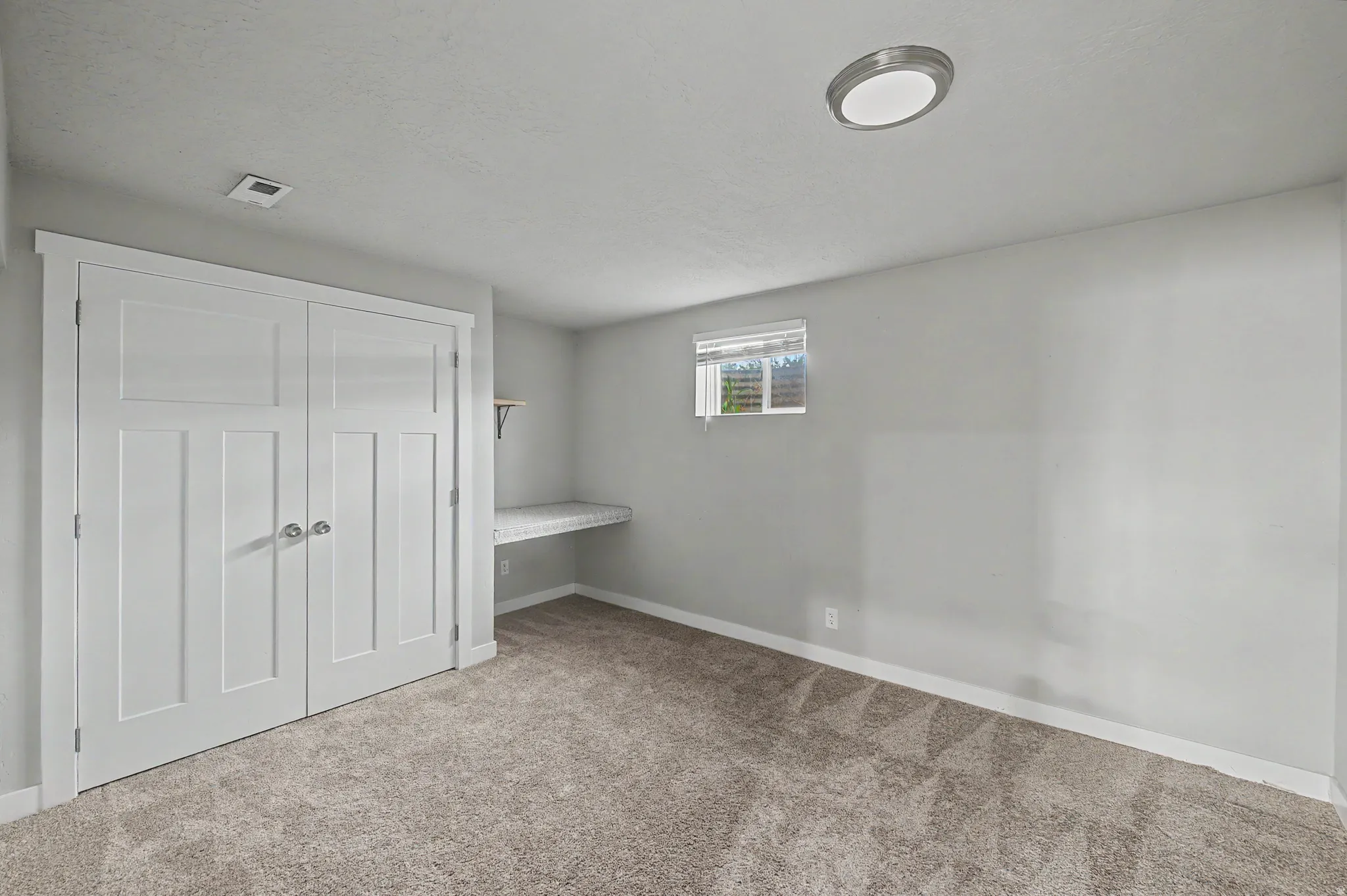 Unfurnished bedroom with light carpet and a closet