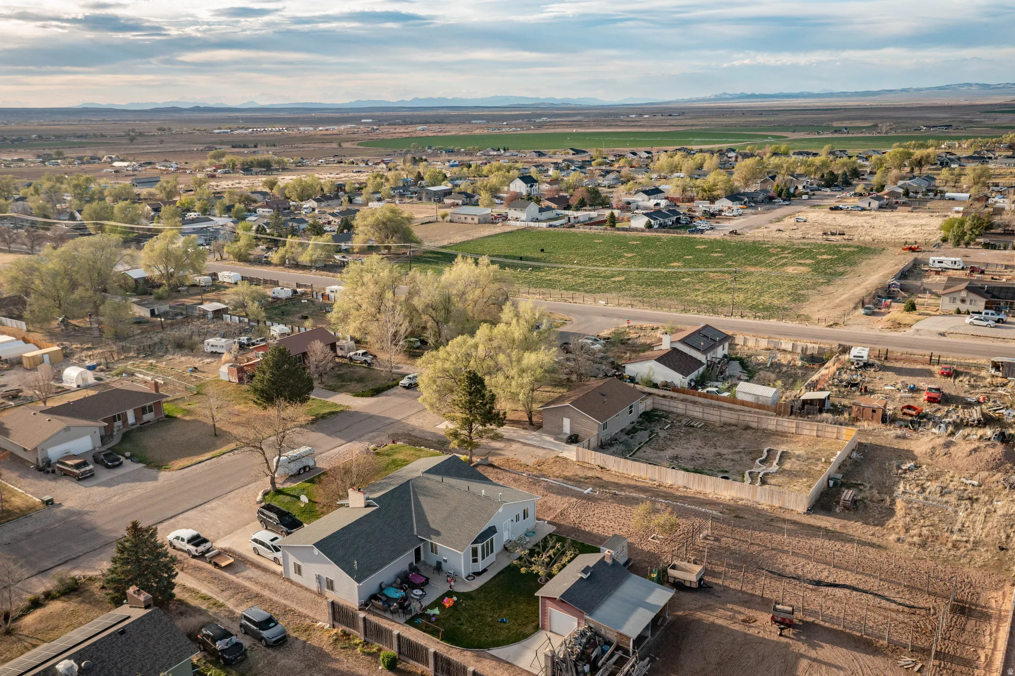 Aerial view of property and surrounding area with nearby suburban area and mountains