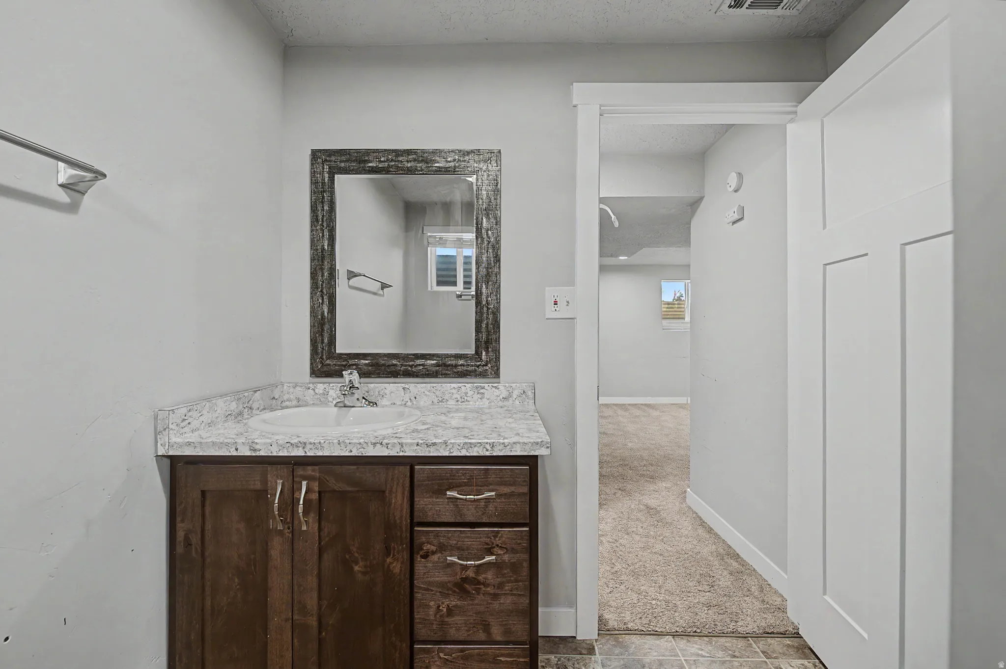 Half bath with vanity and a textured ceiling