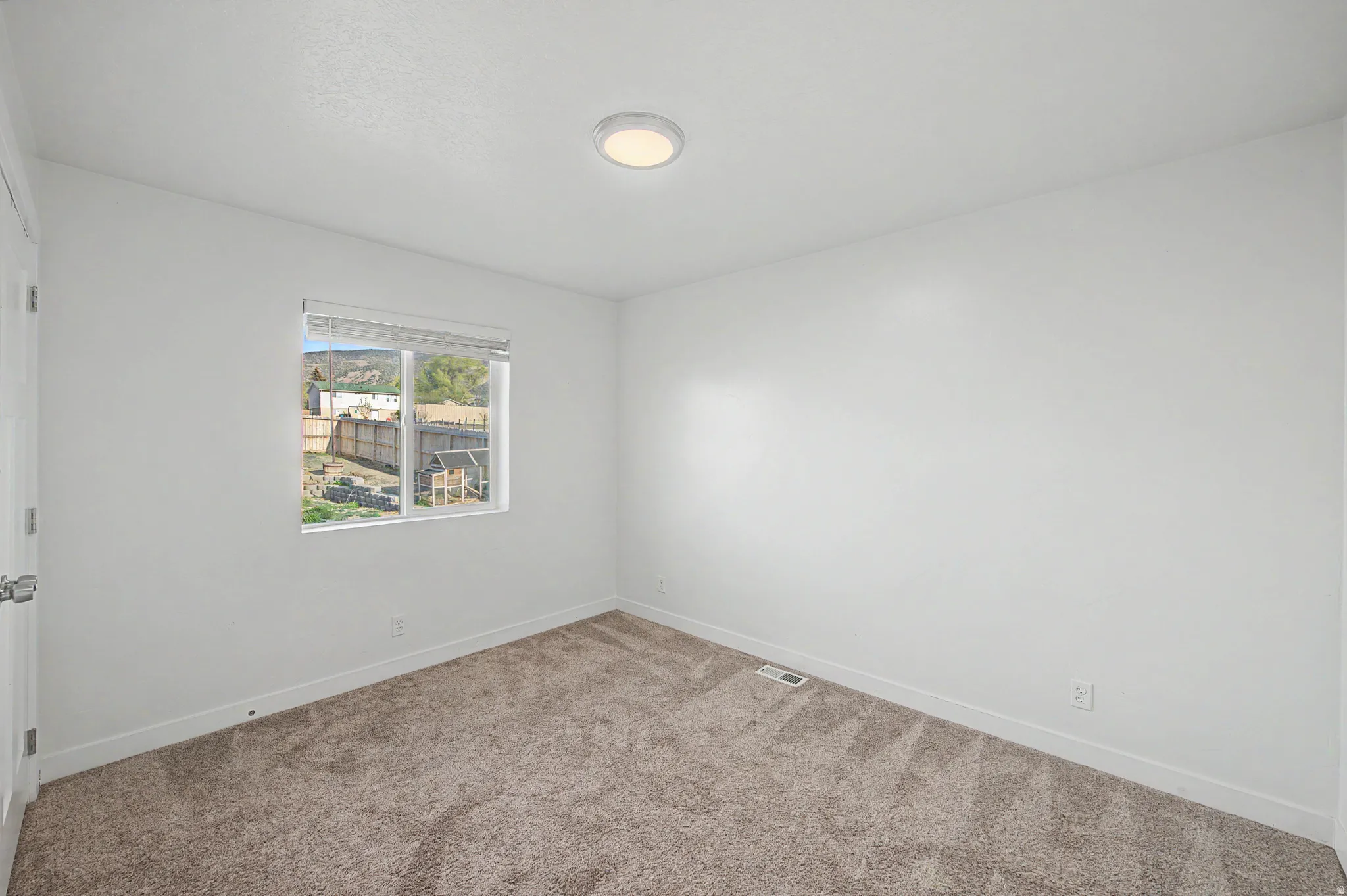 Carpeted spare room with baseboards