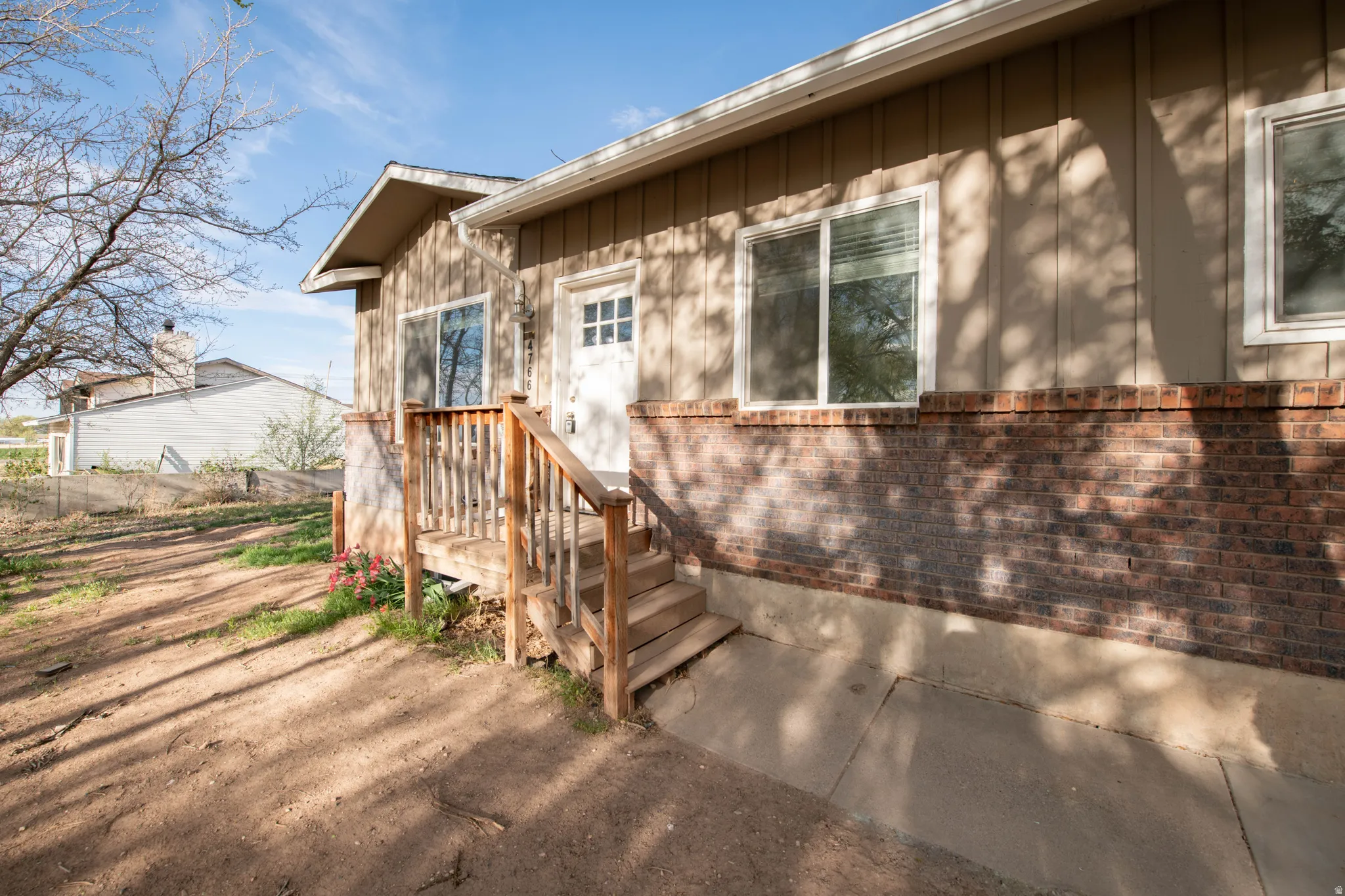 Property entrance featuring board and batten siding and brick siding