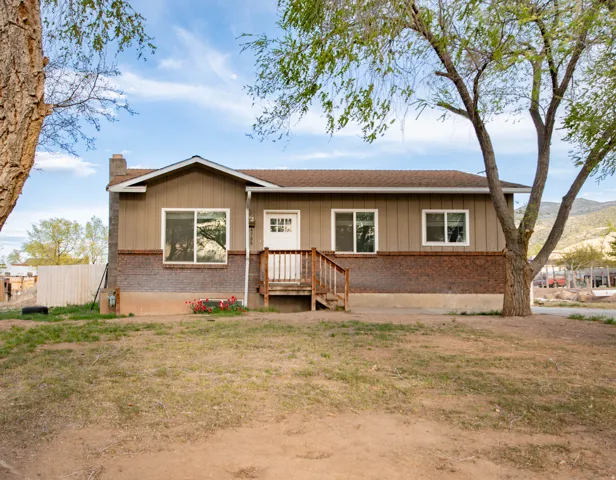 Single story home with a chimney, brick siding, and board and batten siding