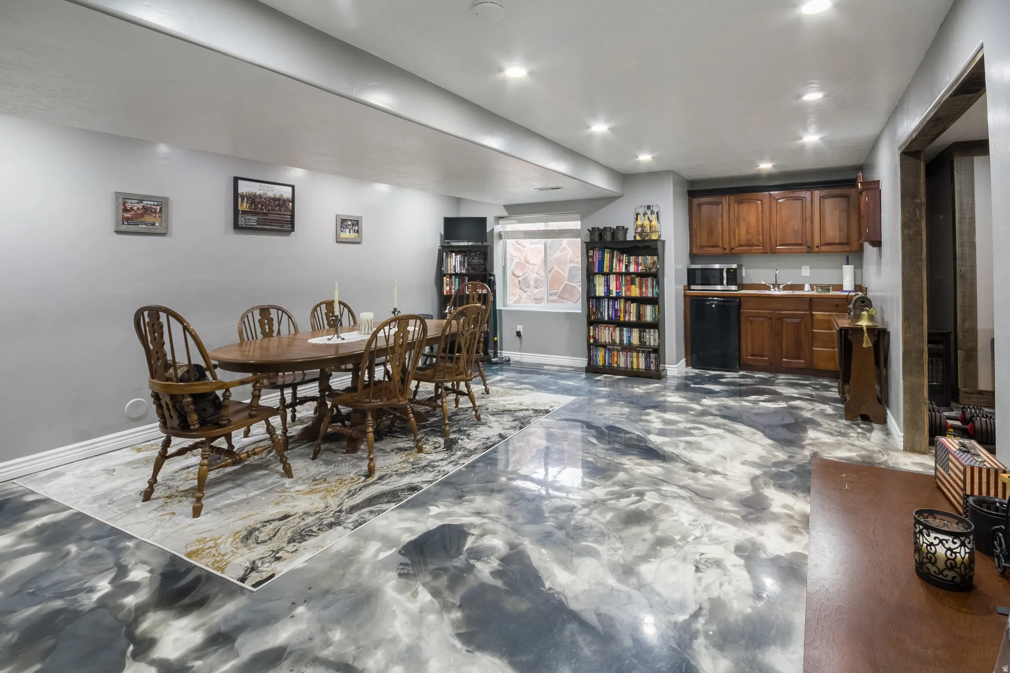 Dining space with bar with sink, recessed lighting, and finished concrete flooring