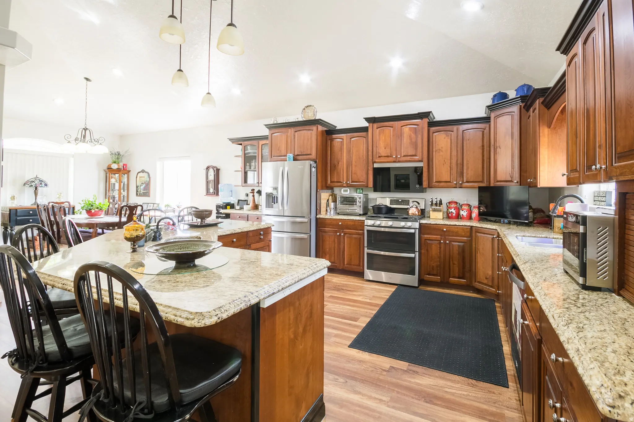 Kitchen featuring lofted ceiling, a large island, stainless steel appliances, a kitchen breakfast bar, and light wood-type flooring