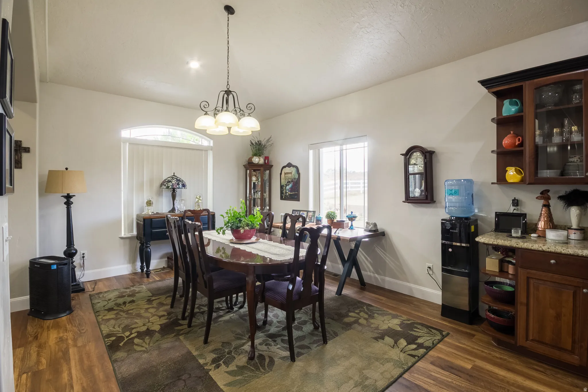 Dining space with hanging lights, dark wood-style floors, and vaulted ceiling