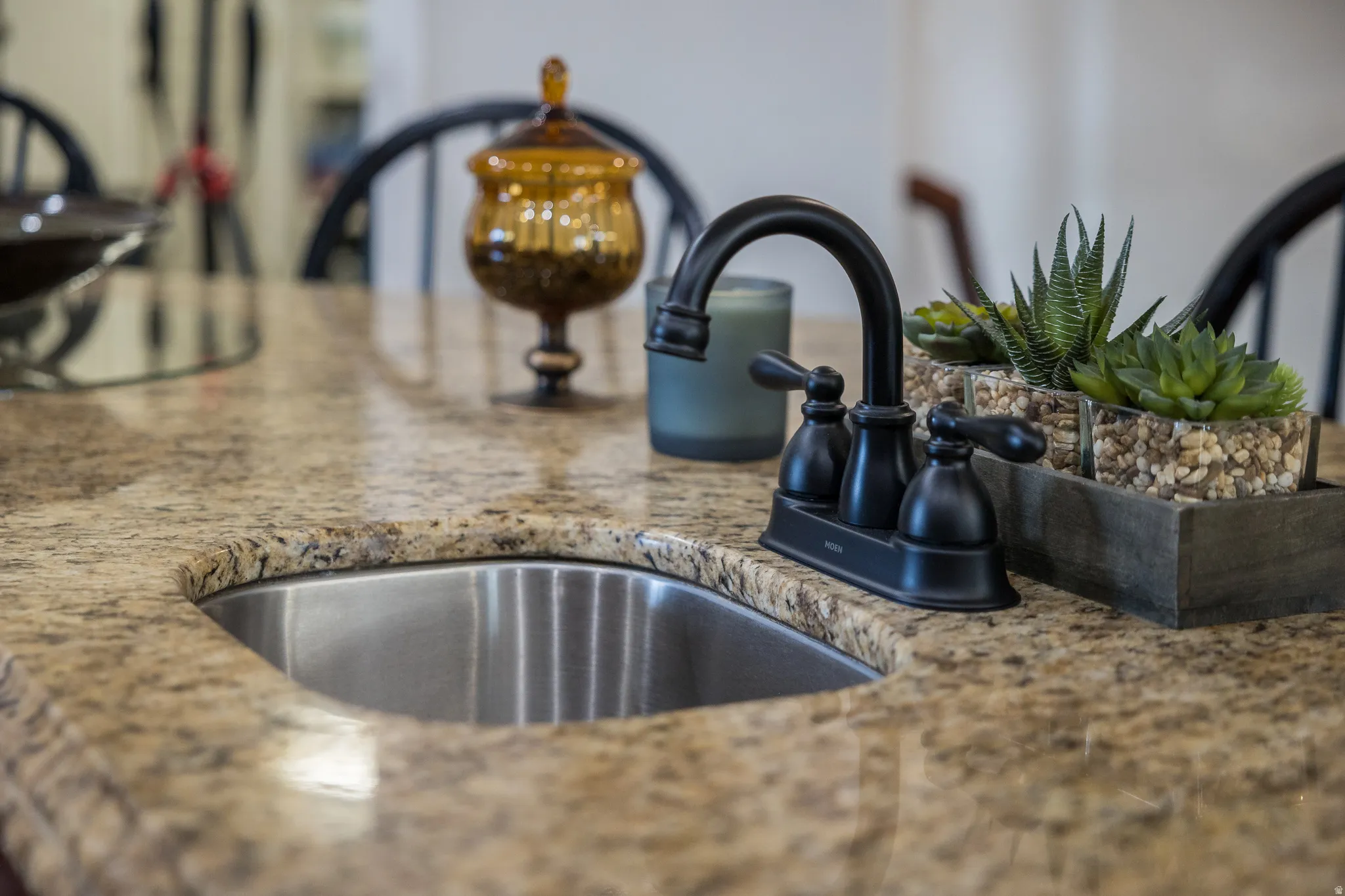 Detailed view of light stone countertops and a sink