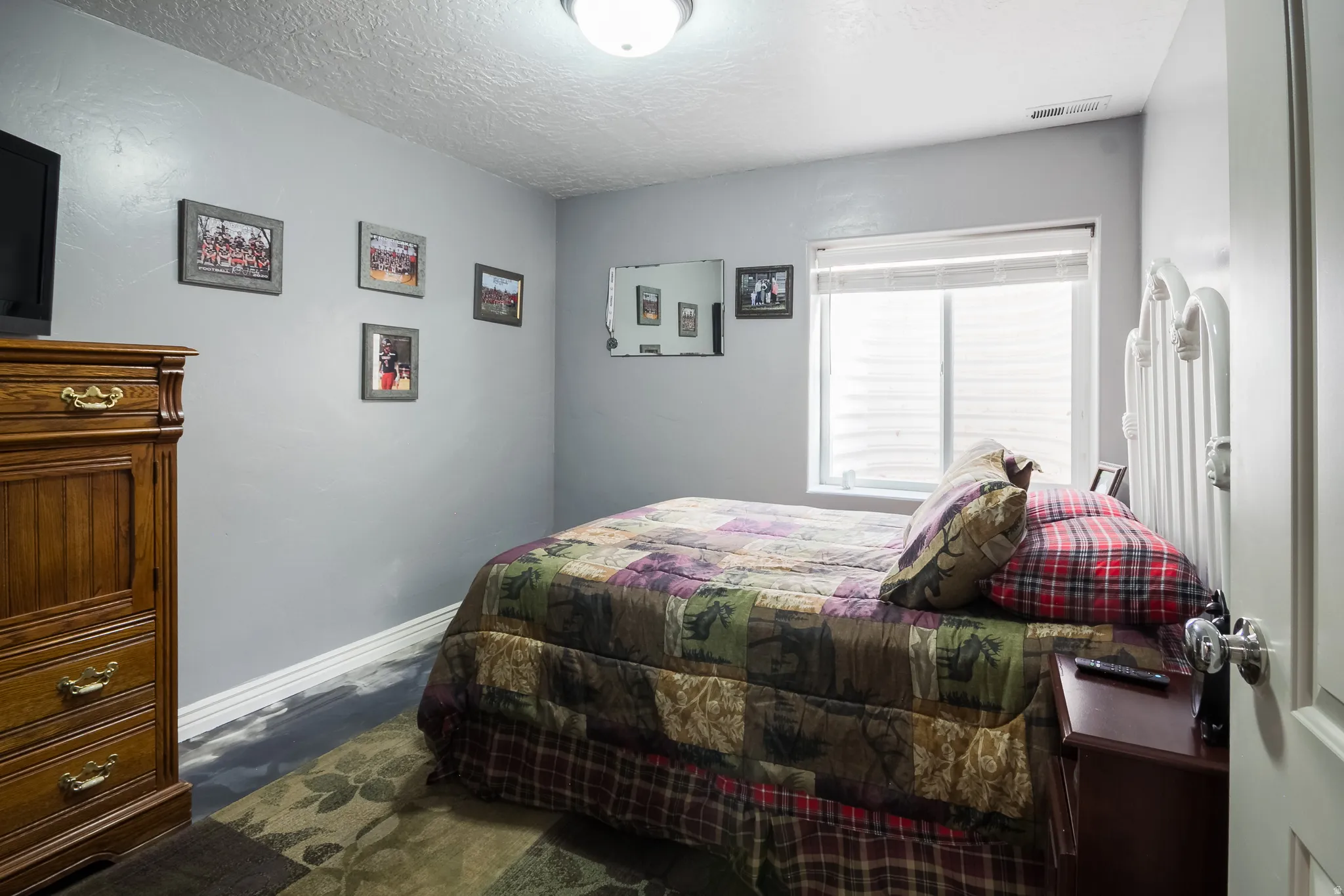 Bedroom featuring baseboards and a textured ceiling