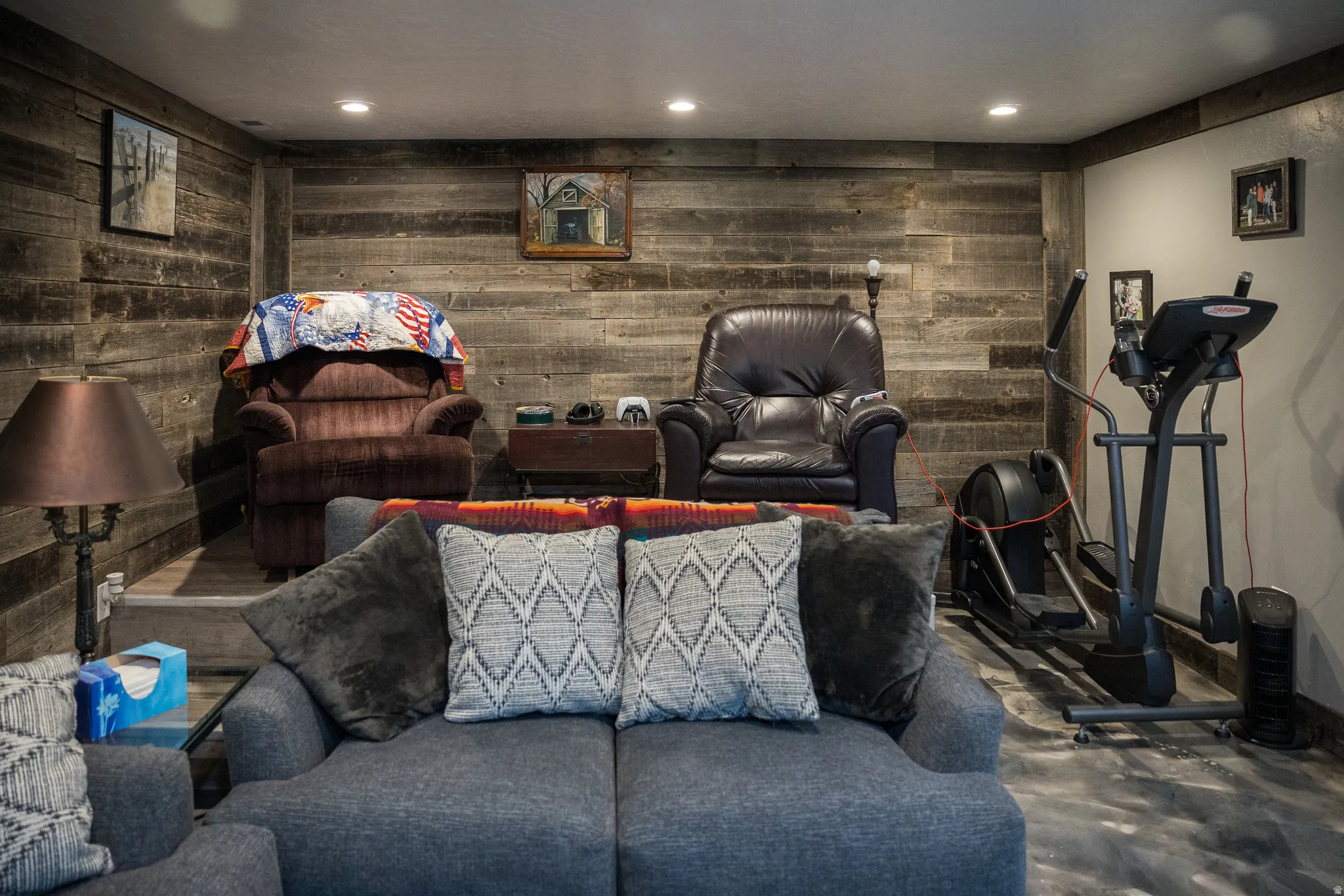 Living area with recessed lighting, concrete flooring, and wooden walls