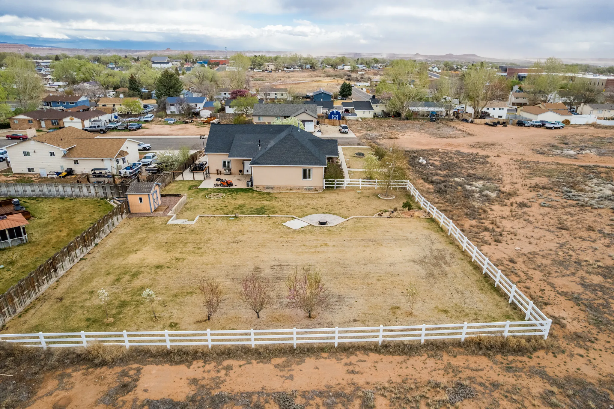 Aerial view of property and surrounding area featuring nearby suburban area