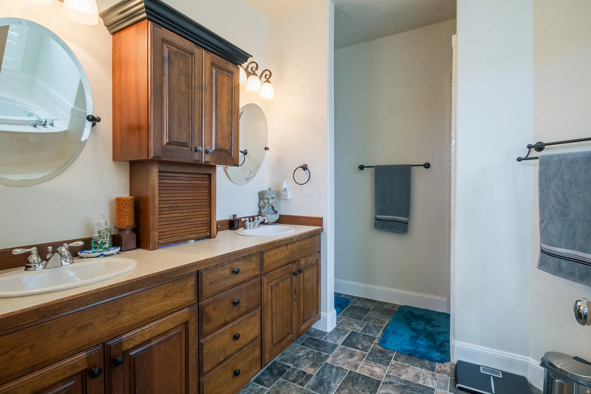 Full bathroom with double vanity and stone finish floors