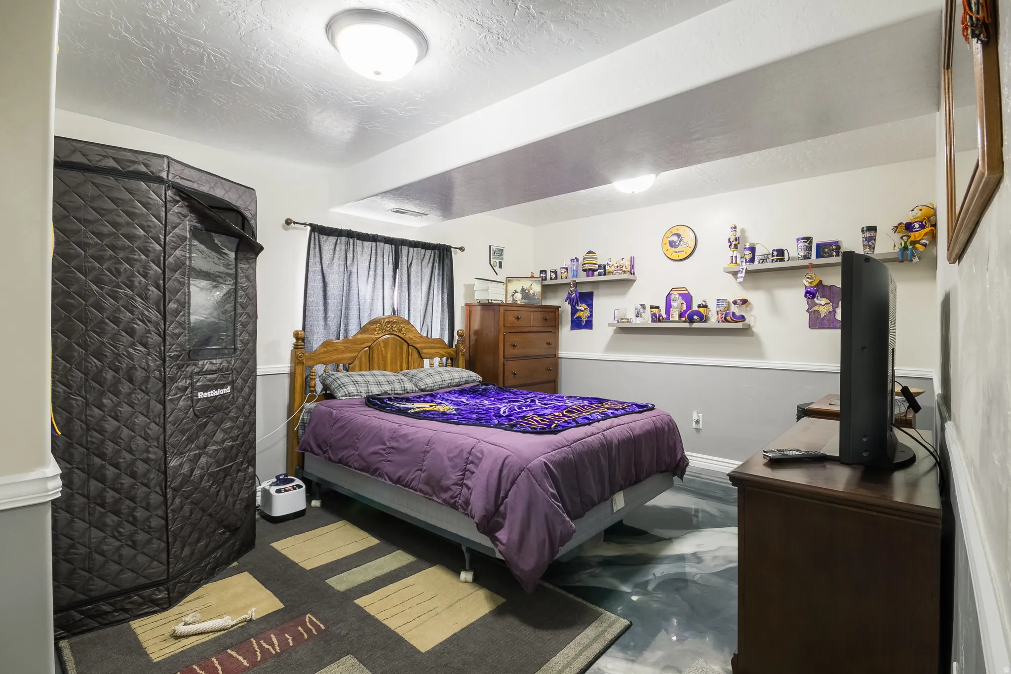 Bedroom featuring finished concrete flooring and a textured ceiling