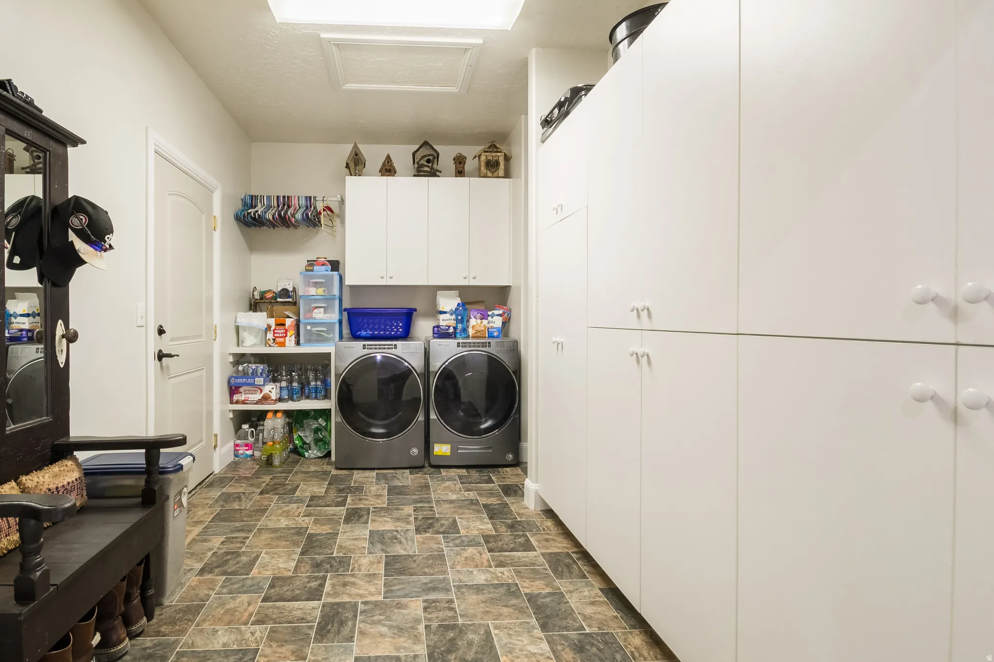 Laundry area with stone finish flooring, cabinet space, and separate washer and dryer