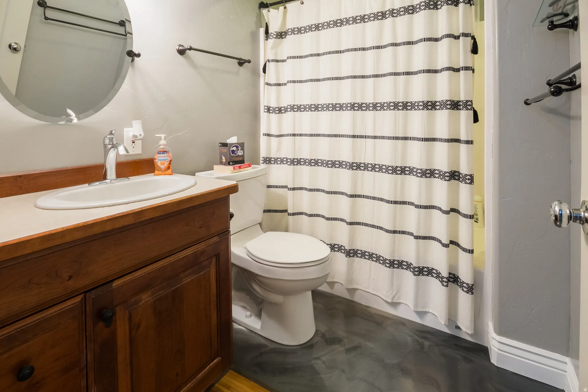 Full bathroom featuring vanity and a textured wall